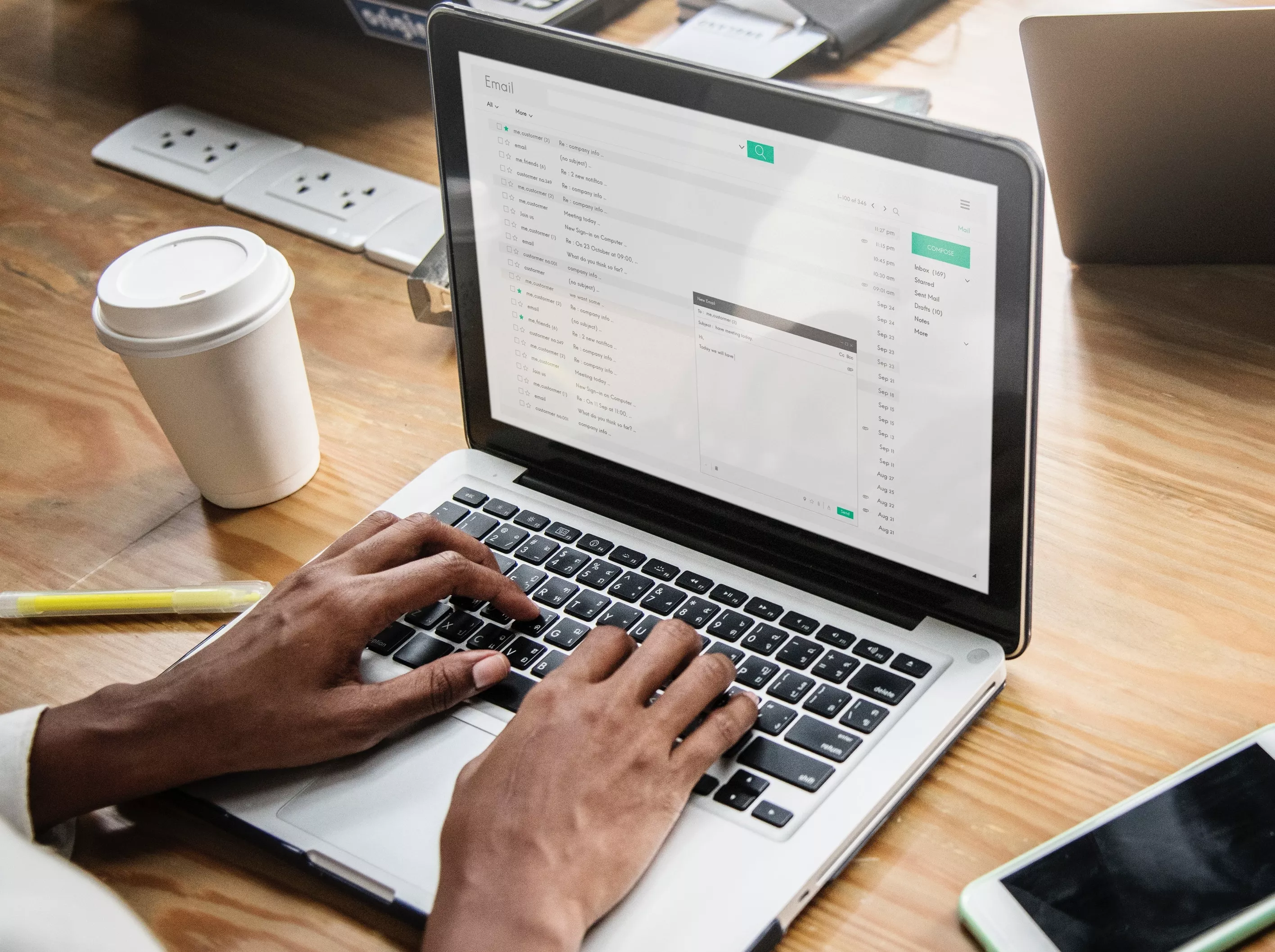 Hands typing on laptop, email open.