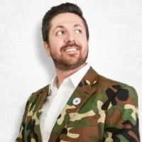 Man in camouflage jacket, looking thoughtful.