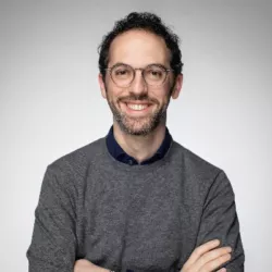 Man in glasses, smiling, entrepreneur.