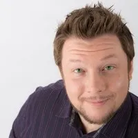 Man with green eyes, smiling.