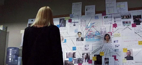 Woman reviewing investigation board.