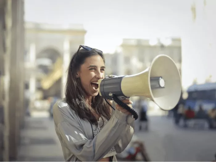 Woman shouting into megaphone.